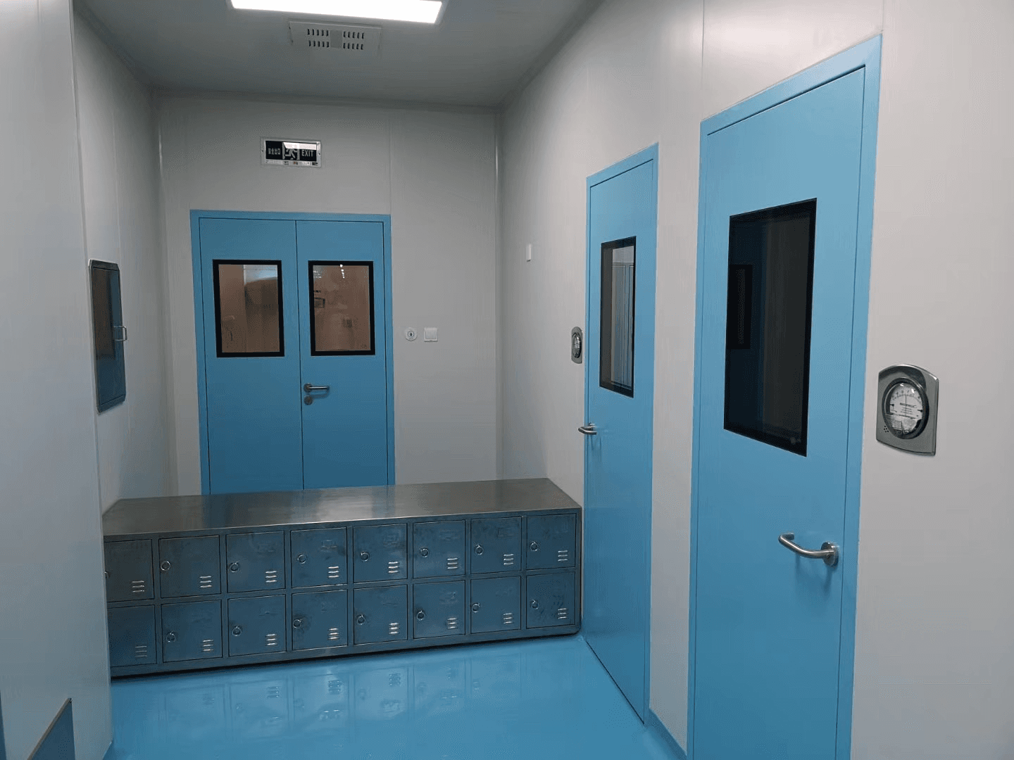 GMP airlock changing room with stainless steel lockers and pressure gauges