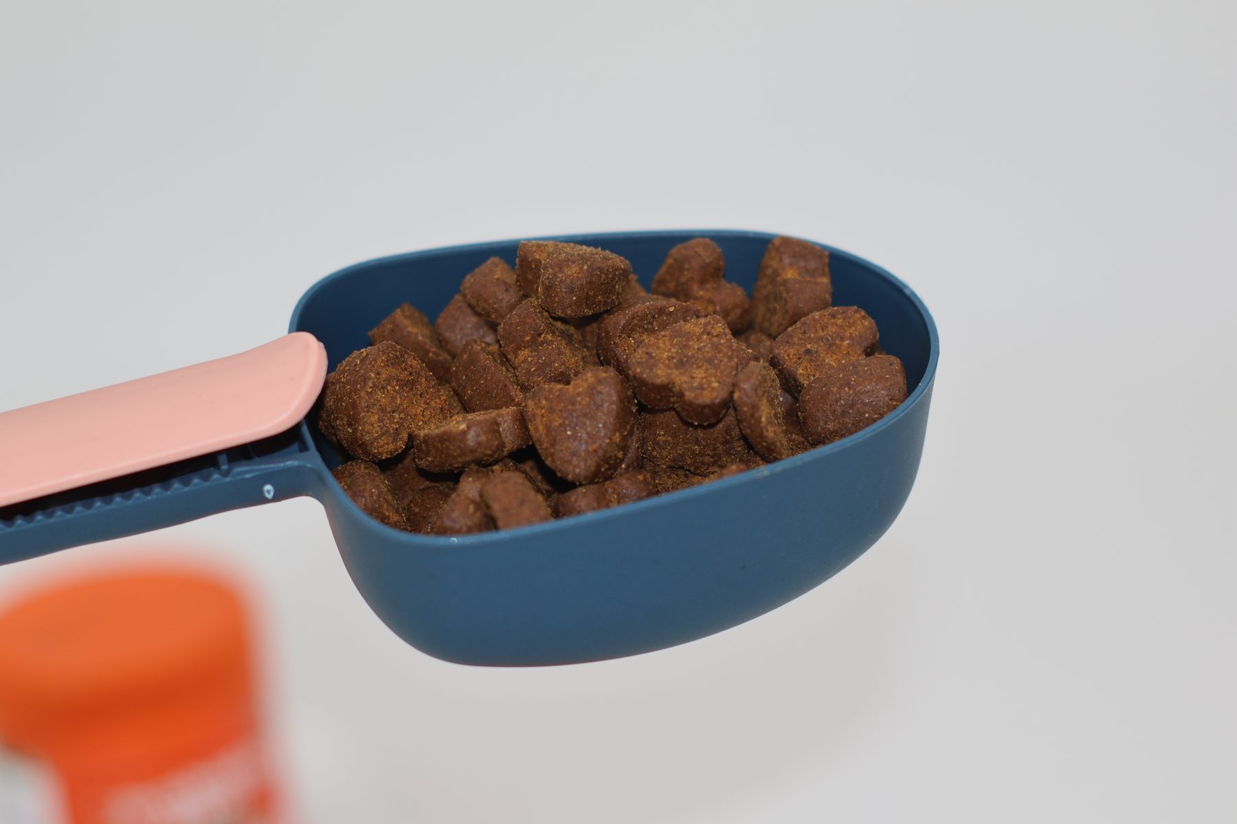 Heart-shaped chicken-flavour soft chews in a scoop, the piece the extrusion line actually packs
