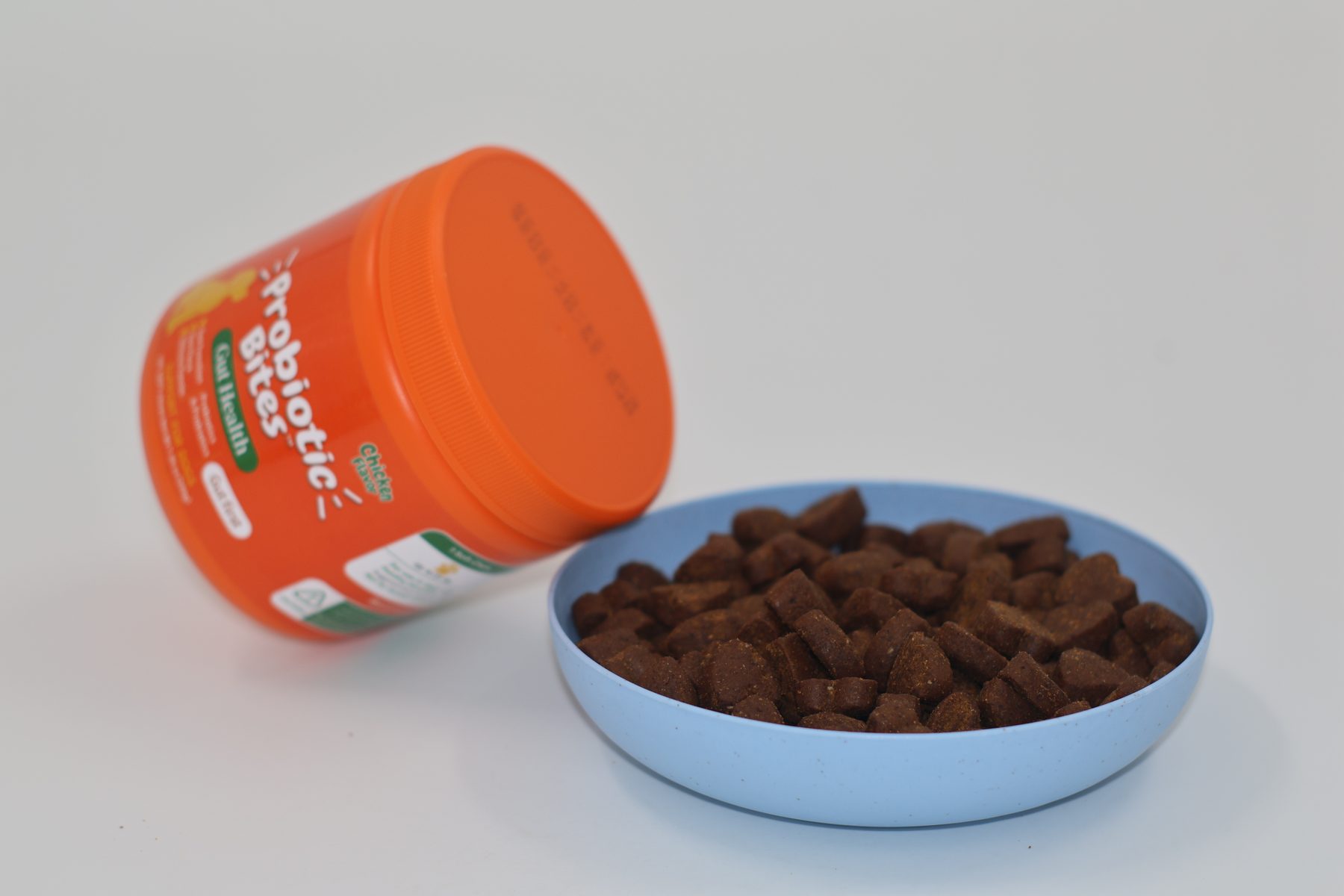 Probiotic gut-health chews in a bowl beside the stock jar. The chew is the compliance story; powder is usually the honest CFU story